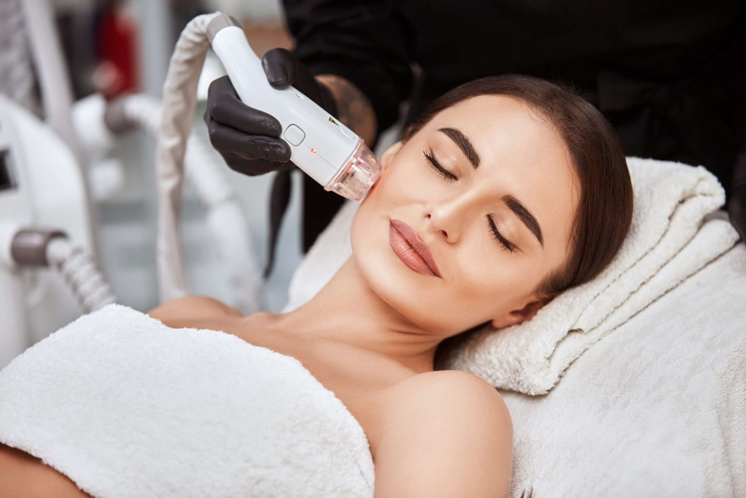 close up woman receiving facial treatment with laser by beautician spa salon pleasent woman lying with her eyes closed getting face theraphy scaled